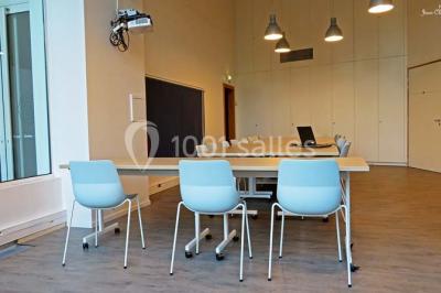 Un groupe de personnes rassemblé sous un grand parasol éclairé par des lumières violettes, dans un jardin de nuit.