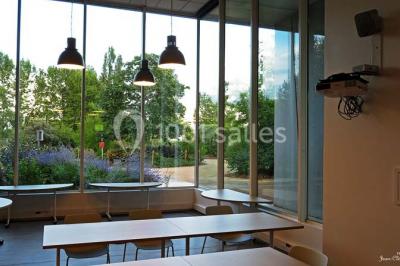 Un groupe de personnes rassemblé sous un grand parasol éclairé par des lumières violettes, dans un jardin de nuit.
