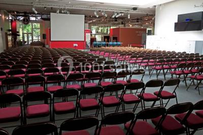 Un groupe de personnes rassemblé sous un grand parasol éclairé par des lumières violettes, dans un jardin de nuit.