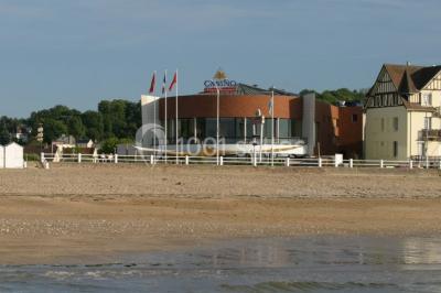 Vue intérieure d'une salle circulaire avec de grandes baies vitrées donnant sur la mer et un ciel partiellement nuageux.