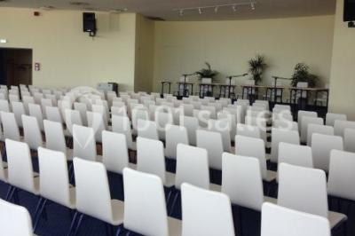 Miniature Location salle Villers-sur-Mer (Calvados) - Salle Panoramique Villers Sur Mer #3 Salle avec de grandes baies vitrées, tables dressées avec nappes orange, assiettes bleues et verres, vue sur un bâtiment…