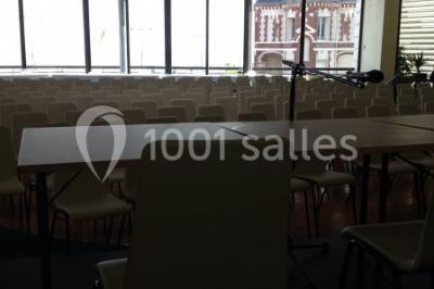 Miniature Location salle Villers-sur-Mer (Calvados) - Salle Panoramique Villers Sur Mer #4 Salle avec de grandes baies vitrées, tables dressées avec nappes orange, assiettes bleues et verres, vue sur un bâtiment…