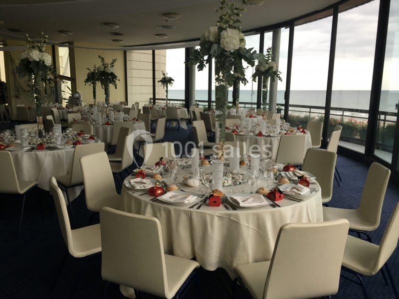 Location salle Villers-sur-Mer (Calvados) - Salle Panoramique Villers Sur Mer #13 Salle de réception élégante avec tables rondes dressées, décor floral et vue sur la mer à travers de grandes baies vitrées.