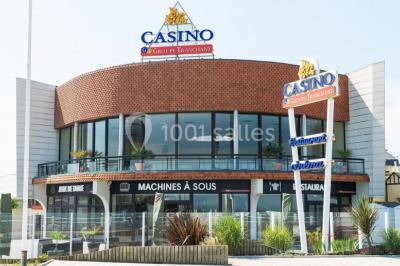 Miniature Location salle Villers-sur-Mer (Calvados) - Salle Panoramique Villers Sur Mer #2 Salle avec de grandes baies vitrées, tables dressées avec nappes orange, assiettes bleues et verres, vue sur un bâtiment…