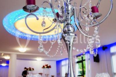 Salle de bain lumineuse avec deux lavabos, miroirs et murs ornés de mosaïques dorées.