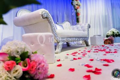Salle de bain lumineuse avec deux lavabos, miroirs et murs ornés de mosaïques dorées.