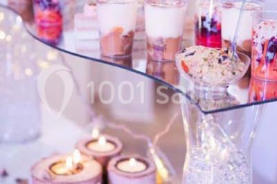 Salle de bain lumineuse avec deux lavabos, miroirs et murs ornés de mosaïques dorées.