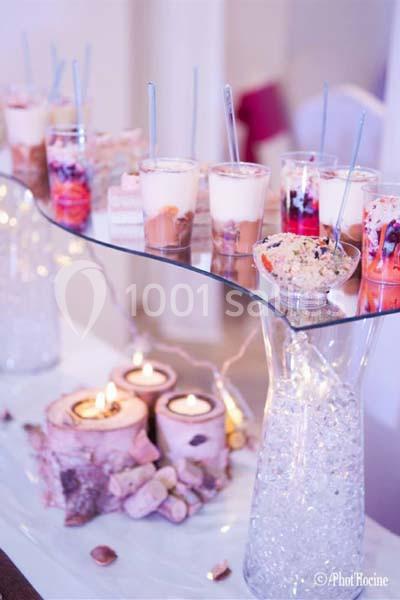 Desserts variés en verrines sur une table décorée avec des bougies et des éléments naturels en bois.