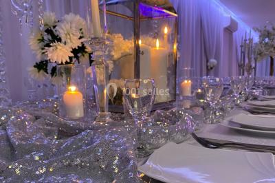 Salle de bain lumineuse avec deux lavabos, miroirs et murs ornés de mosaïques dorées.