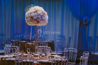 Salle de bain lumineuse avec deux lavabos, miroirs et murs ornés de mosaïques dorées.