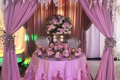 Salle de bain lumineuse avec deux lavabos, miroirs et murs ornés de mosaïques dorées.