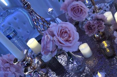Salle de bain lumineuse avec deux lavabos, miroirs et murs ornés de mosaïques dorées.