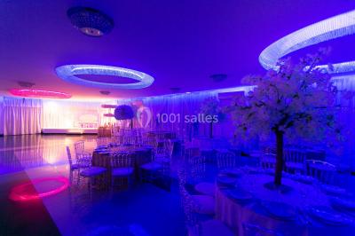 Salle de bain lumineuse avec deux lavabos, miroirs et murs ornés de mosaïques dorées.
