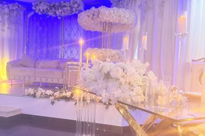 Salle de bain lumineuse avec deux lavabos, miroirs et murs ornés de mosaïques dorées.