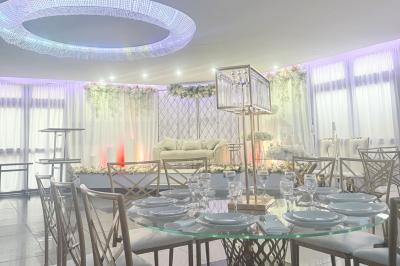 Salle de bain lumineuse avec deux lavabos, miroirs et murs ornés de mosaïques dorées.