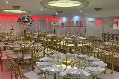 Salle de bain lumineuse avec deux lavabos, miroirs et murs ornés de mosaïques dorées.