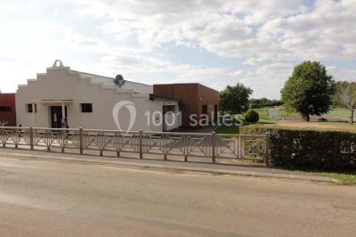 Cuisine avec un évier en inox, un plan de travail sombre, un réfrigérateur blanc et des murs bleus.