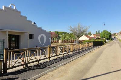 Cuisine avec un évier en inox, un plan de travail sombre, un réfrigérateur blanc et des murs bleus.