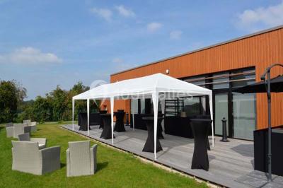 Cuisine avec un évier en inox, un plan de travail sombre, un réfrigérateur blanc et des murs bleus.