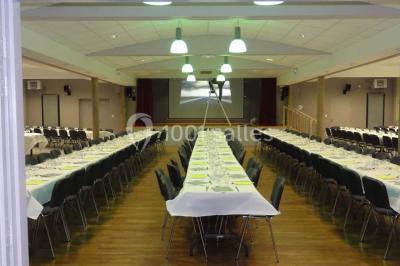 Cuisine avec un évier en inox, un plan de travail sombre, un réfrigérateur blanc et des murs bleus.