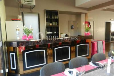 Cuisine avec un évier en inox, un plan de travail sombre, un réfrigérateur blanc et des murs bleus.