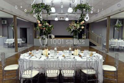 Cuisine avec un évier en inox, un plan de travail sombre, un réfrigérateur blanc et des murs bleus.