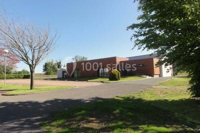 Cuisine avec un évier en inox, un plan de travail sombre, un réfrigérateur blanc et des murs bleus.