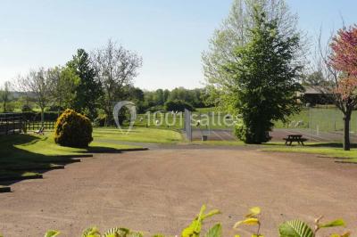 Cuisine avec un évier en inox, un plan de travail sombre, un réfrigérateur blanc et des murs bleus.
