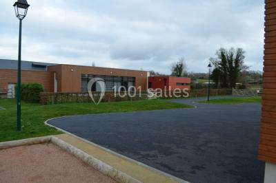 Cuisine avec un évier en inox, un plan de travail sombre, un réfrigérateur blanc et des murs bleus.