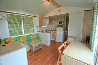 Buffet en bois décoré avec des bocaux de bonbons colorés et une guirlande ’Candy Bar’ dans un cadre rustique.