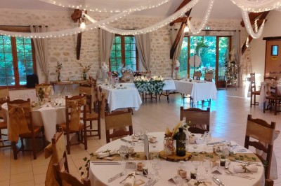 Buffet en bois décoré avec des bocaux de bonbons colorés et une guirlande ’Candy Bar’ dans un cadre rustique.