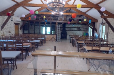 Buffet en bois décoré avec des bocaux de bonbons colorés et une guirlande ’Candy Bar’ dans un cadre rustique.