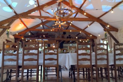 Buffet en bois décoré avec des bocaux de bonbons colorés et une guirlande ’Candy Bar’ dans un cadre rustique.