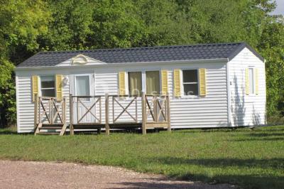 Buffet en bois décoré avec des bocaux de bonbons colorés et une guirlande ’Candy Bar’ dans un cadre rustique.