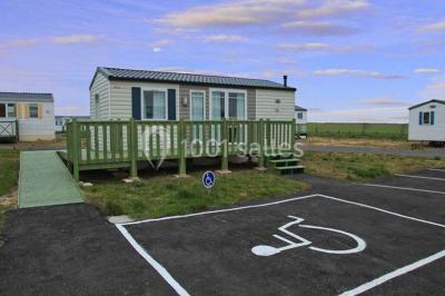 Buffet en bois décoré avec des bocaux de bonbons colorés et une guirlande ’Candy Bar’ dans un cadre rustique.