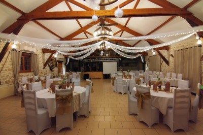 Buffet en bois décoré avec des bocaux de bonbons colorés et une guirlande ’Candy Bar’ dans un cadre rustique.