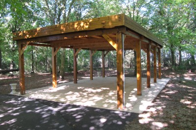 Buffet en bois décoré avec des bocaux de bonbons colorés et une guirlande ’Candy Bar’ dans un cadre rustique.