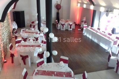 Comptoir en verre avec base en bois sculpté, entouré de portants métalliques avec des cintres noirs dans un espace moderne.