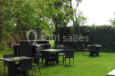 Comptoir en verre avec base en bois sculpté, entouré de portants métalliques avec des cintres noirs dans un espace moderne.