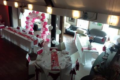 Comptoir en verre avec base en bois sculpté, entouré de portants métalliques avec des cintres noirs dans un espace moderne.