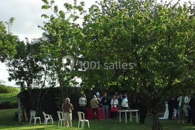 Comptoir en verre avec base en bois sculpté, entouré de portants métalliques avec des cintres noirs dans un espace moderne.
