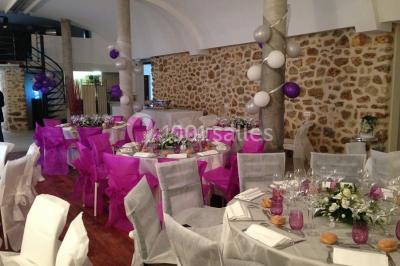 Comptoir en verre avec base en bois sculpté, entouré de portants métalliques avec des cintres noirs dans un espace moderne.