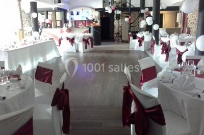 Comptoir en verre avec base en bois sculpté, entouré de portants métalliques avec des cintres noirs dans un espace moderne.