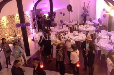 Comptoir en verre avec base en bois sculpté, entouré de portants métalliques avec des cintres noirs dans un espace moderne.