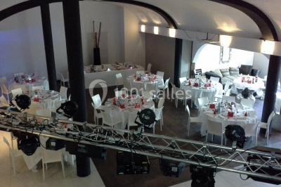 Comptoir en verre avec base en bois sculpté, entouré de portants métalliques avec des cintres noirs dans un espace moderne.