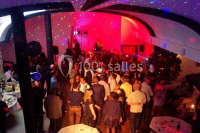 Comptoir en verre avec base en bois sculpté, entouré de portants métalliques avec des cintres noirs dans un espace moderne.