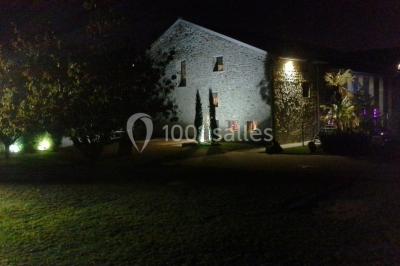 Comptoir en verre avec base en bois sculpté, entouré de portants métalliques avec des cintres noirs dans un espace moderne.