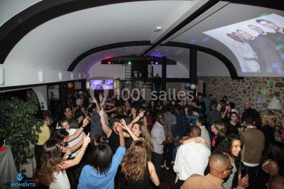Comptoir en verre avec base en bois sculpté, entouré de portants métalliques avec des cintres noirs dans un espace moderne.
