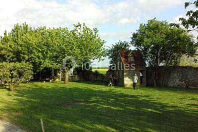 Comptoir en verre avec base en bois sculpté, entouré de portants métalliques avec des cintres noirs dans un espace moderne.
