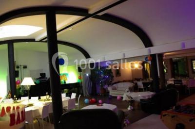 Comptoir en verre avec base en bois sculpté, entouré de portants métalliques avec des cintres noirs dans un espace moderne.